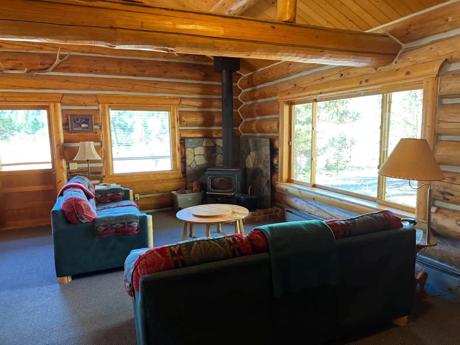Inside the Ponderosa: living room with a woodstove, big windows and two sofas