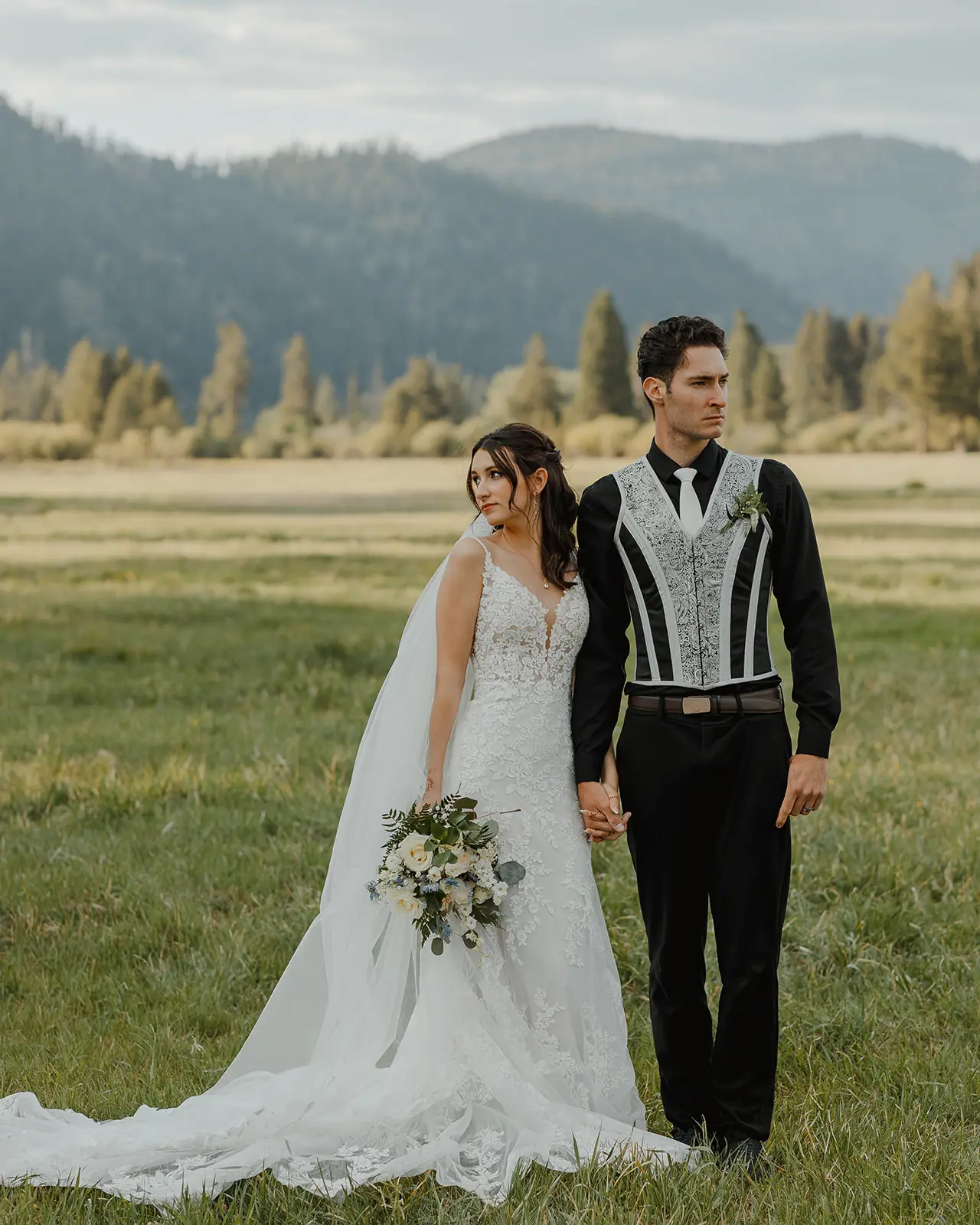 A bride and groom standing together in the green meadow at Alta Ranch