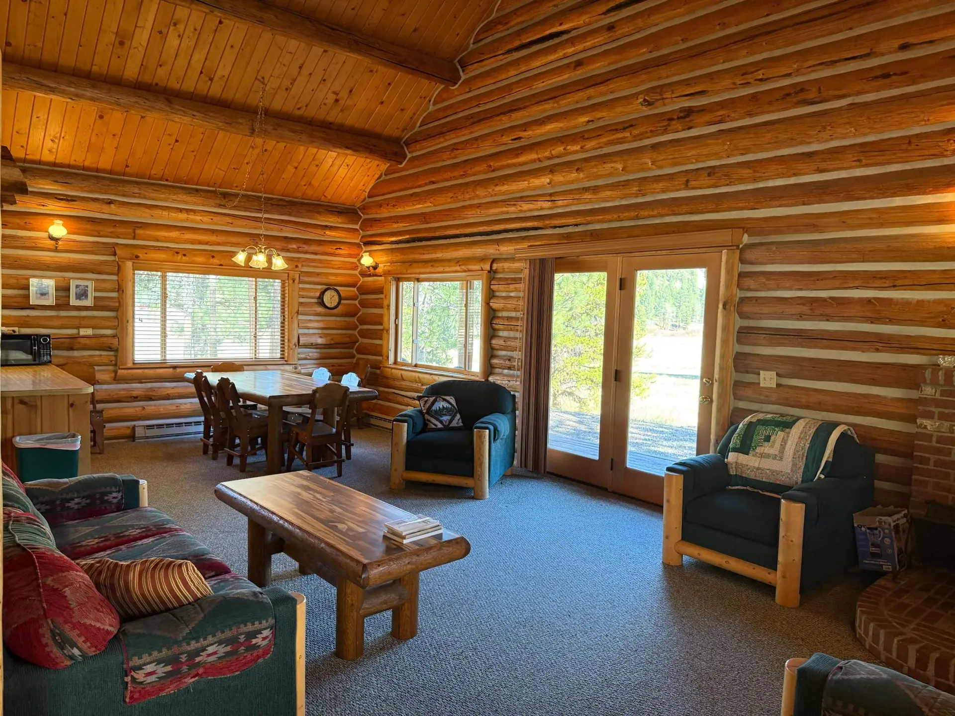 A log cabin living room with a vaulted ceiling and big windows