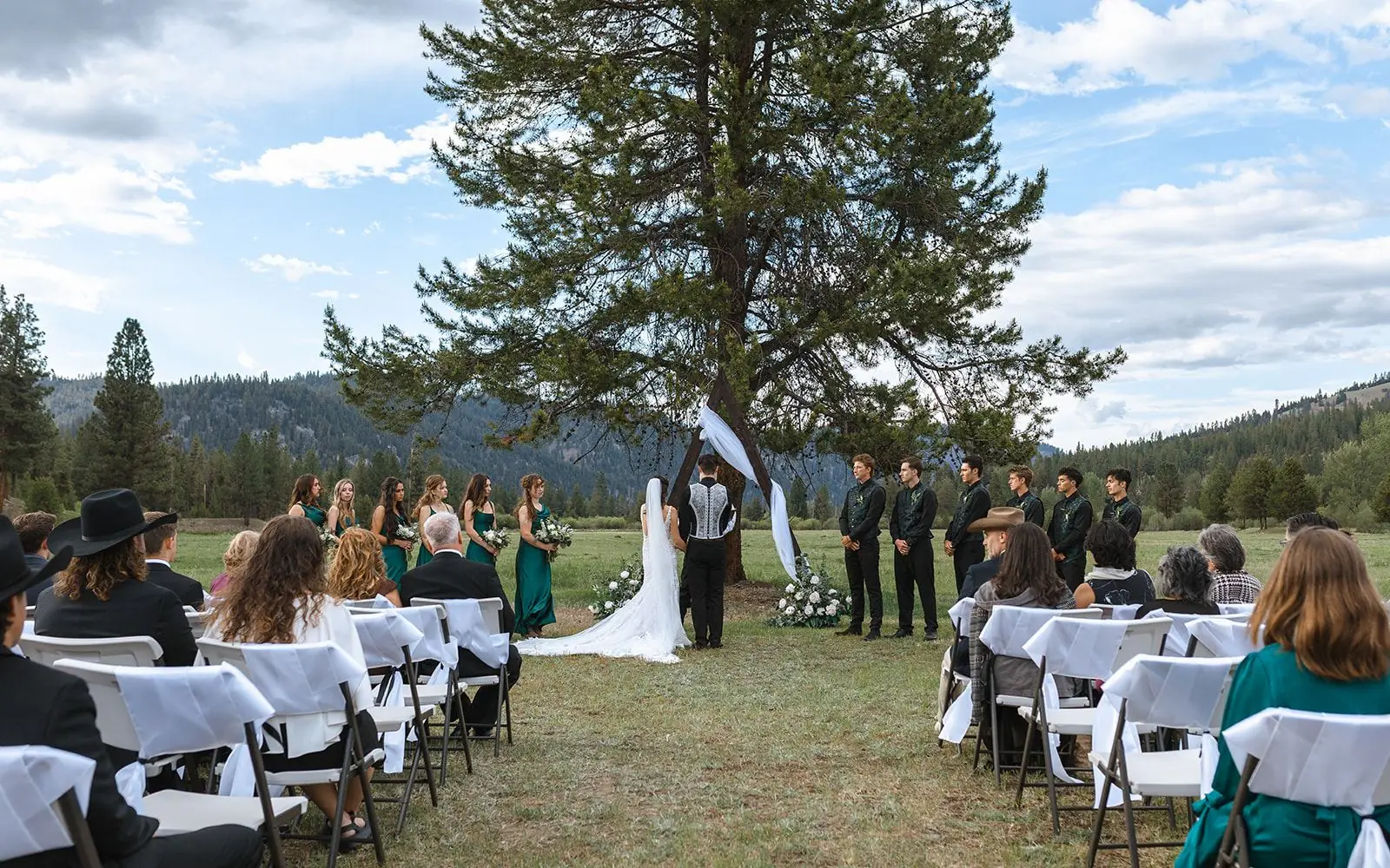 Guests seated for an outdoor ceremony in the meadow at Alta Ranch