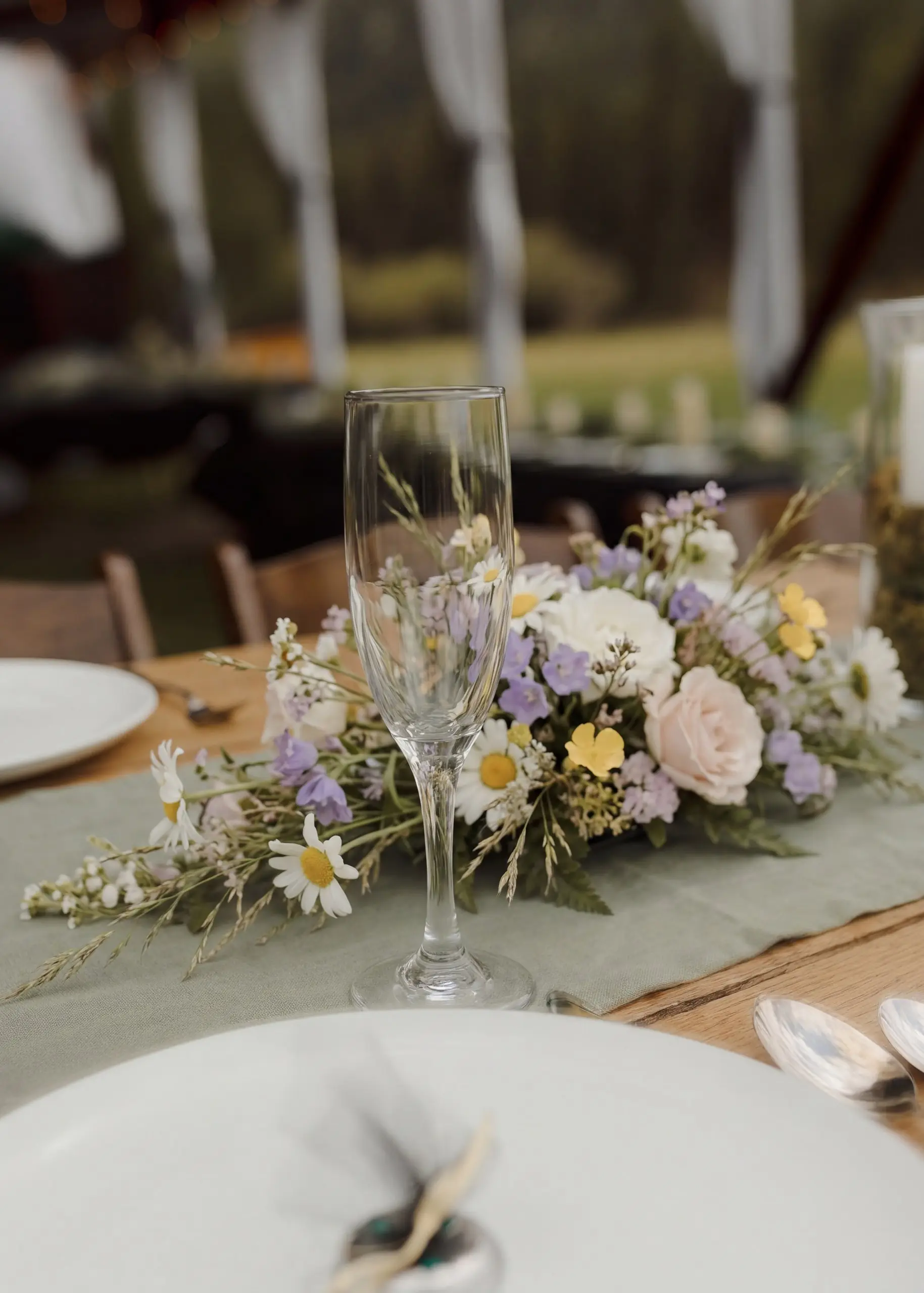 Styling idea: glassware and a wildflower centerpiece on a long table in the hangar